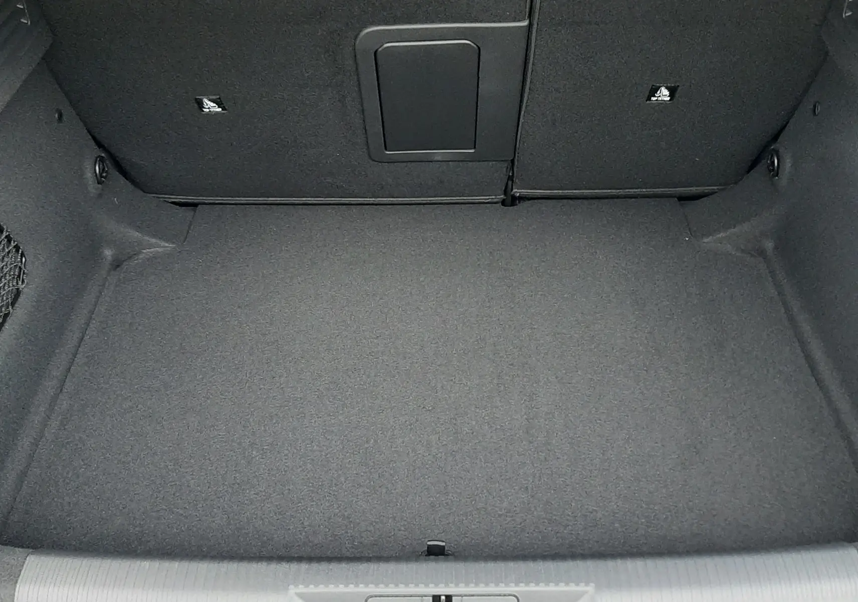 Coffre ouvert vu de dessus de la Peugeot 308 1.2 Hybrid 145ch GT Bleu Lagoa, intérieur noir et tapis plat.