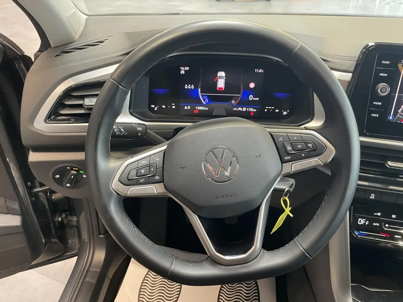 Vue intérieure centrée sur le volant cuir multifonction et le tableau de bord digital du Volkswagen T-Roc gris Indium.