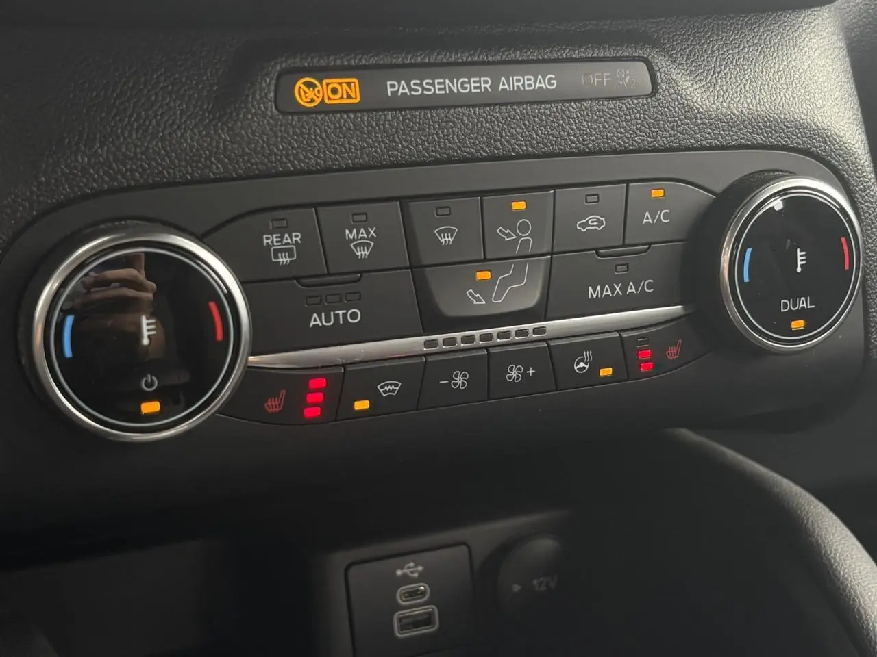 Gros plan sur la console centrale du Ford Kuga 2023, montrant les commandes de climatisation et sièges chauffants.