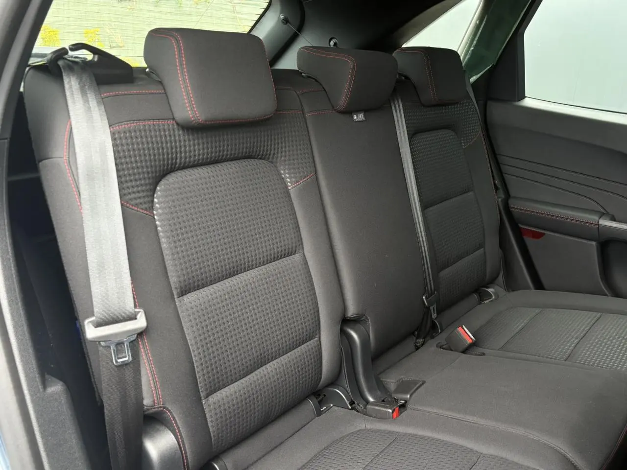Vue intérieure des sièges arrière noirs avec surpiqûres rouges du Ford Kuga 2.0 EcoBlue 120 BVA ST-Line 2023.
