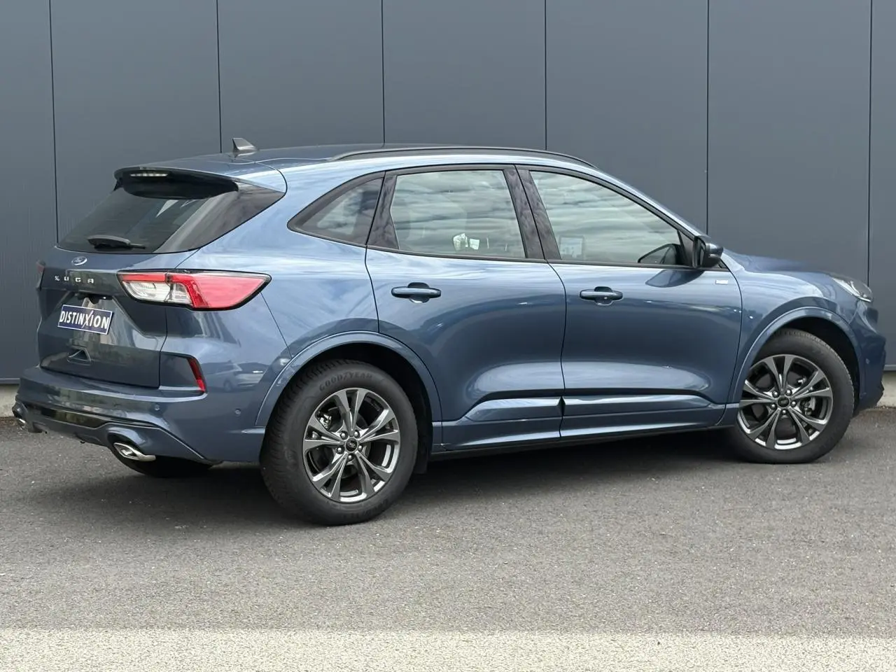 Ford Kuga gris azur en vue profil droit, avec jantes alliage 18 pouces et double sortie d’échappement ST-Line.
