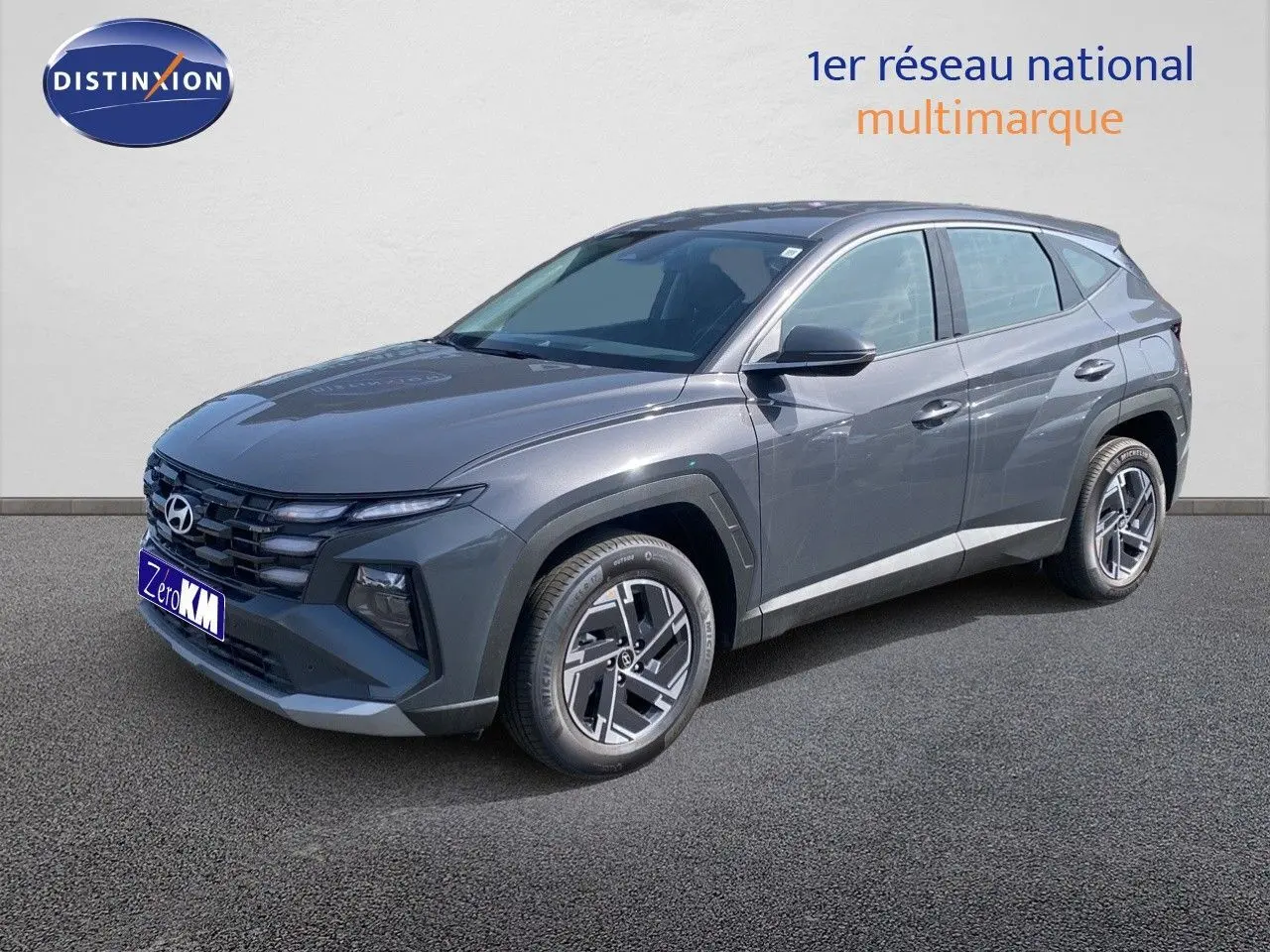 Hyundai Tucson gris Ecotronic Metal en 3/4 avant droit, SUV hybride avec jantes bi-ton et calandre marquée.