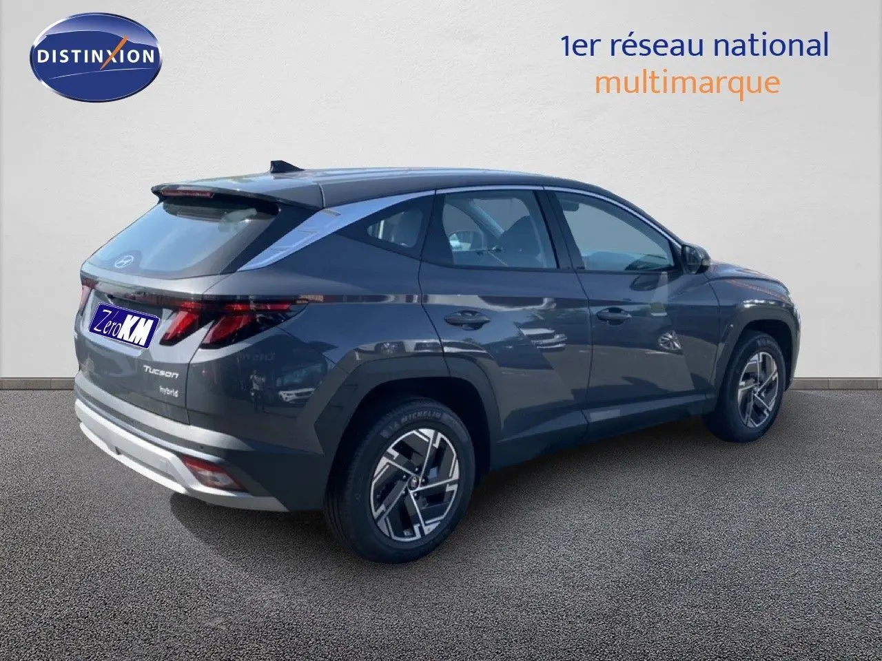 Vue 3/4 arrière droite d'un Hyundai Tucson gris Ecotronic Metal avec jantes bi-ton et feux LED distinctifs.