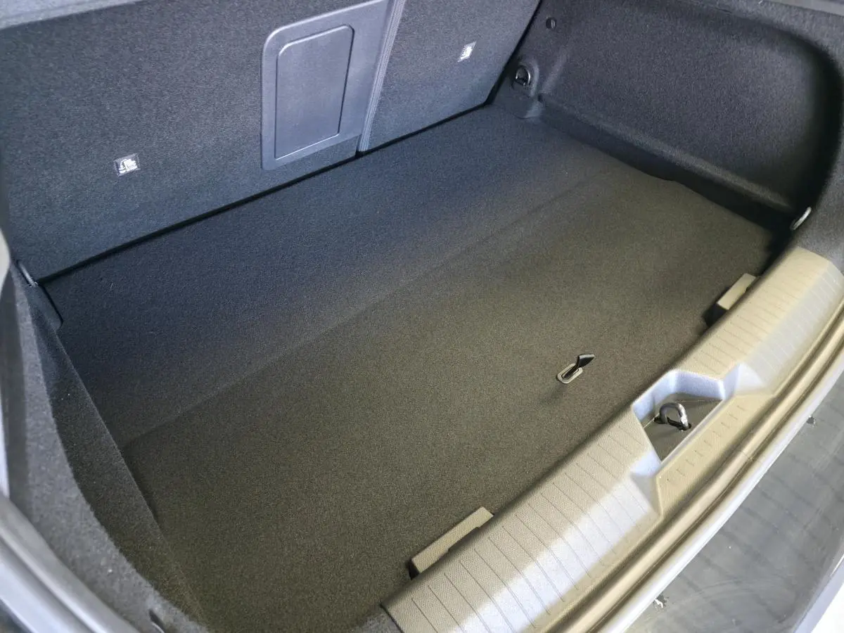 Coffre noir de l’Opel Astra Hybrid 2024, vue plongeante montrant un espace de rangement propre et bien fini.