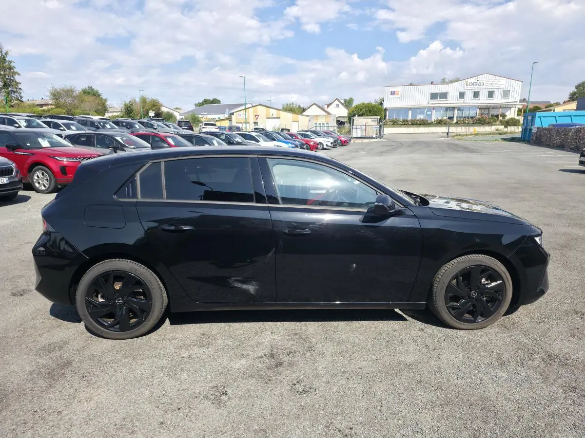 Opel Astra Hybrid 2024 noir vue de profil côté gauche avec jantes alliage noires et vitres surteintées.