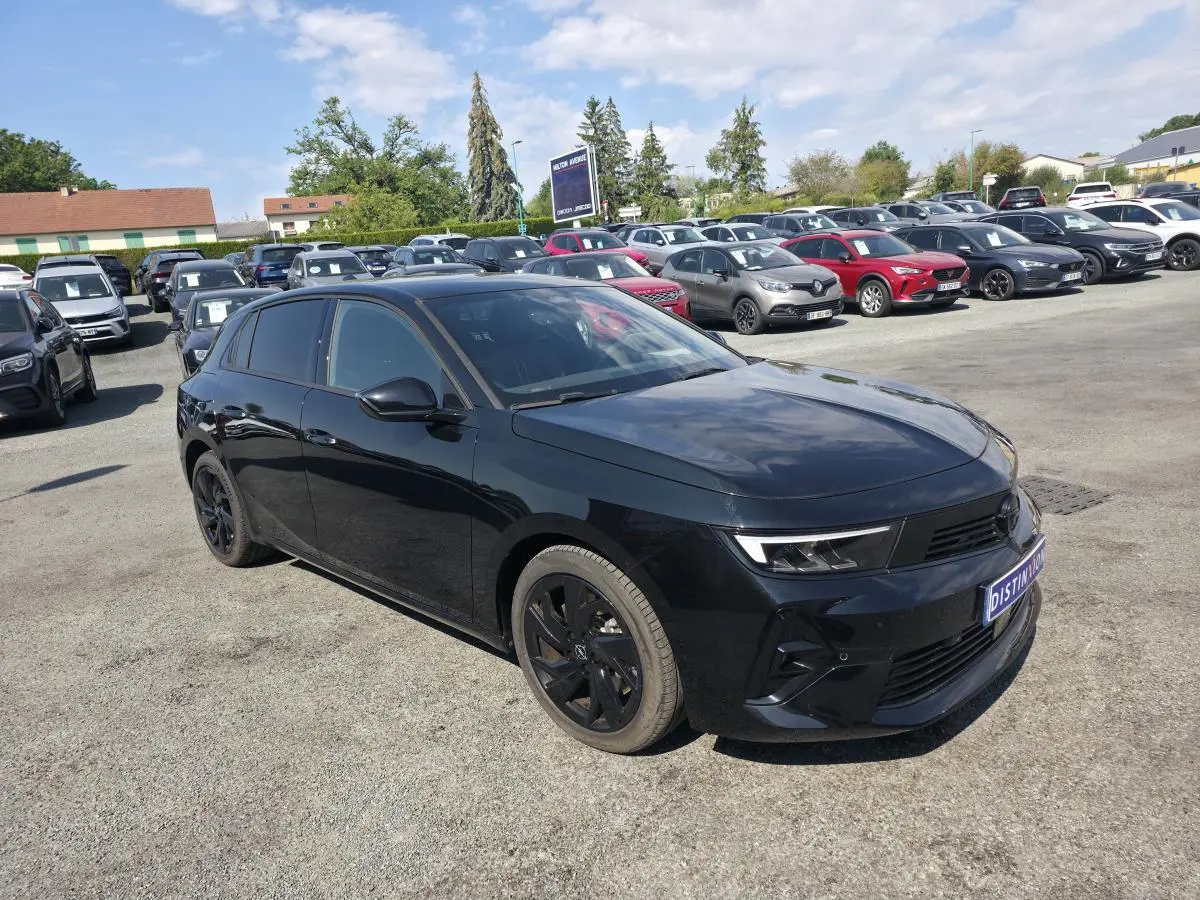 Opel Astra Hybrid 2024 noire en 3/4 avant droit avec jantes alliage noires et vitres surteintées.