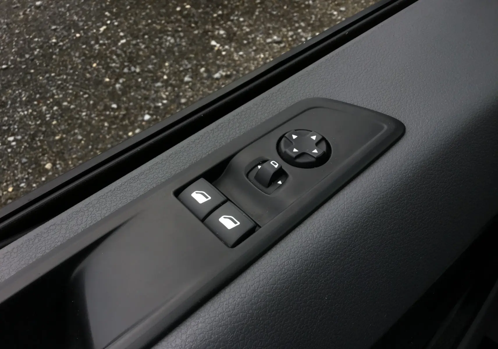 Gros plan sur les commandes électriques des vitres et rétroviseurs côté conducteur de l'Opel Vivaro blanc 2022.