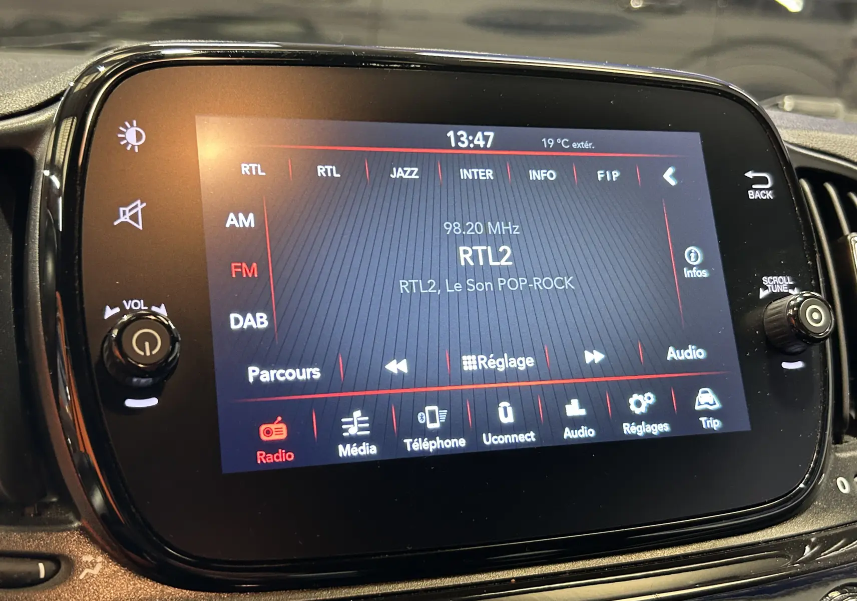 Écran tactile central de la Fiat 500 2023 affichant la radio FM RTL2 avec commandes audio et réglages visibles.
