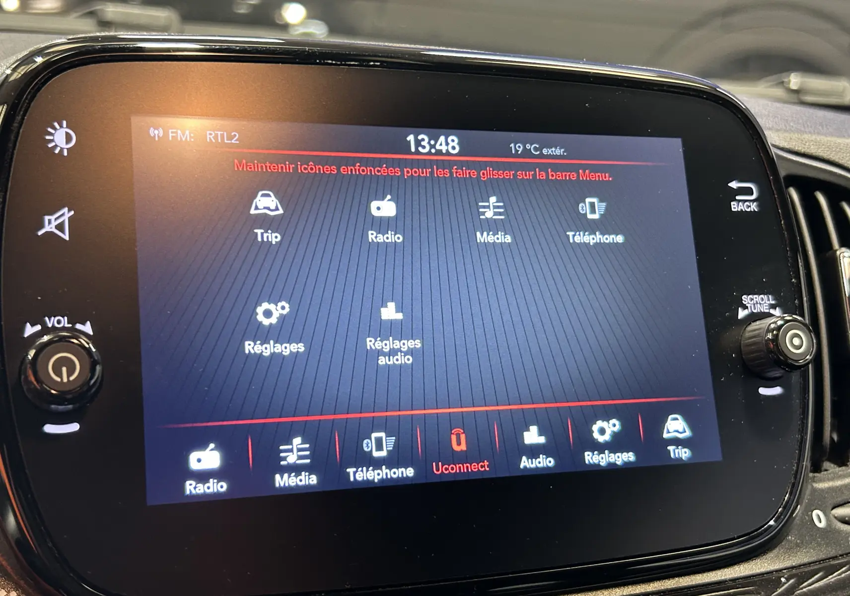 Écran tactile central de la Fiat 500 noir 2023 affichant le menu multimédia avec réglages audio et téléphone.