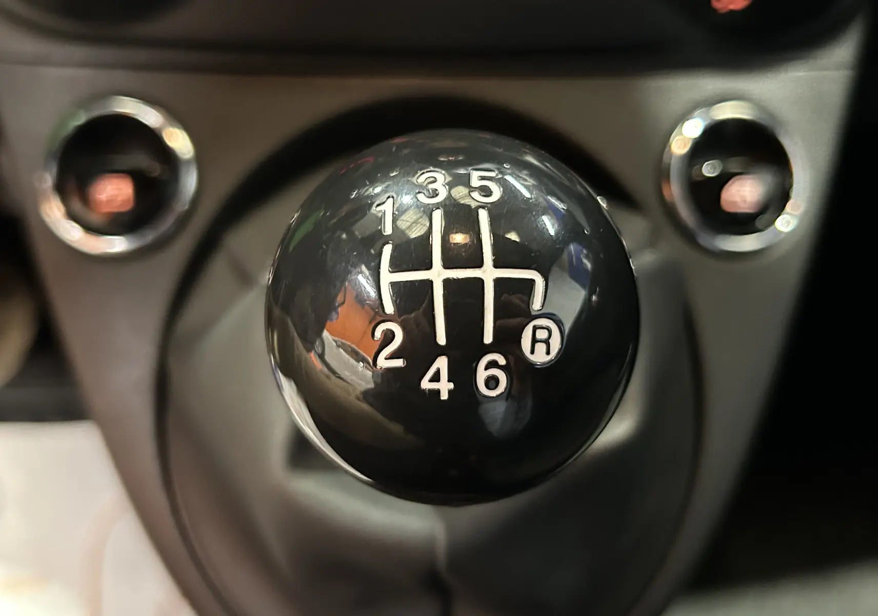 Gros plan sur le pommeau de la boîte manuelle noire à 6 vitesses de la FIAT 500 2023, version Pack Confort.