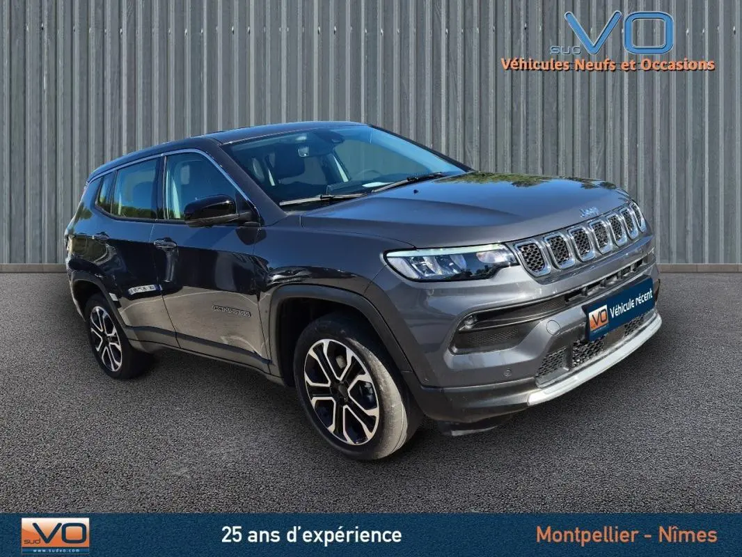 Jeep Compass gris 3/4 avant droit avec jantes alliage 18 pouces, calandre distinctive et phares LED visibles.
