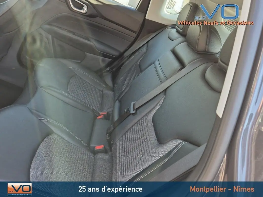 Vue intérieure du siège arrière gris du Jeep Compass 2024, avec ceinture de sécurité et porte arrière visible côté droit.