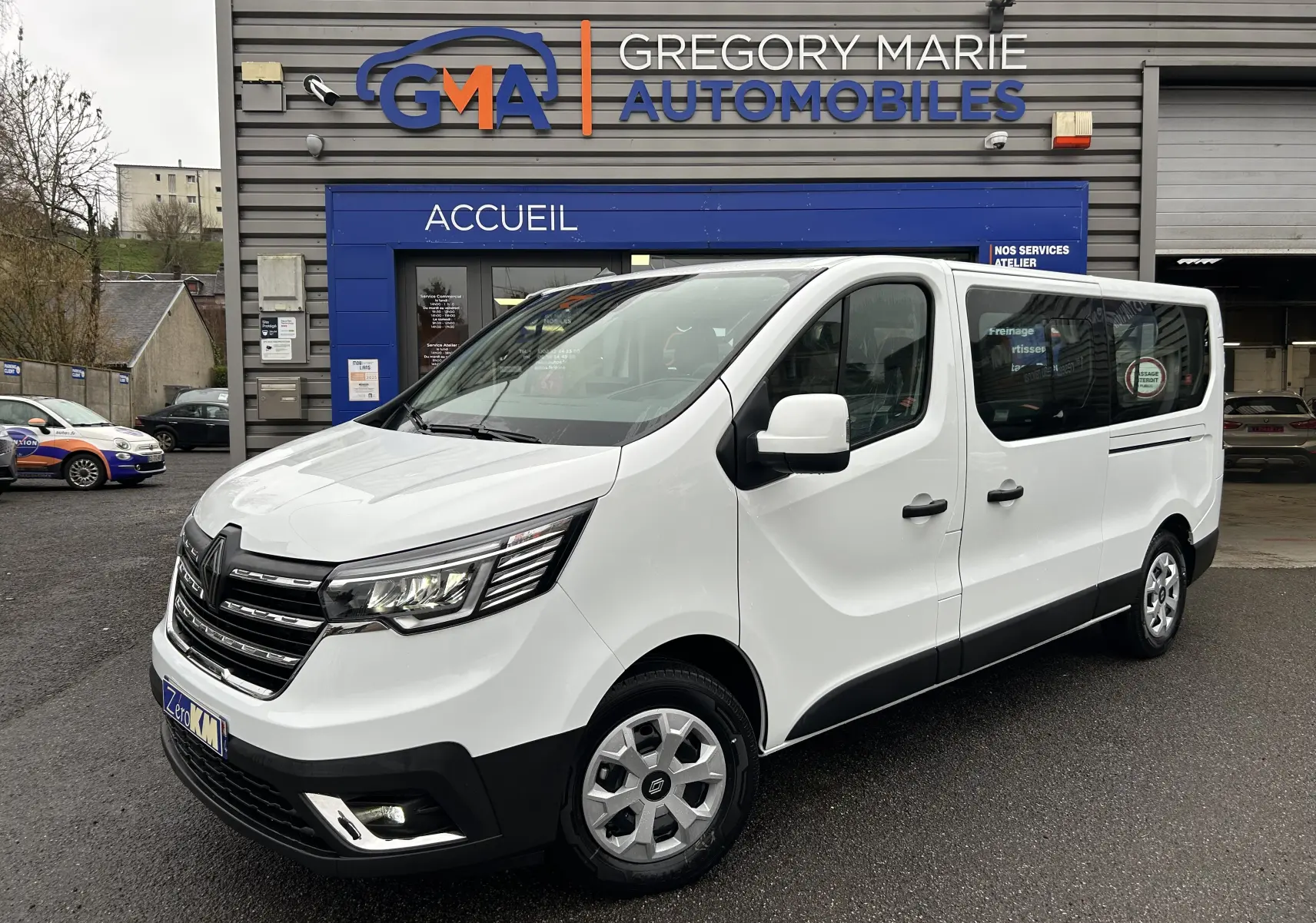 Renault Trafic Combi blanc glacier vu en 3/4 avant droit, porte latérale coulissante et vitres arrière visibles.