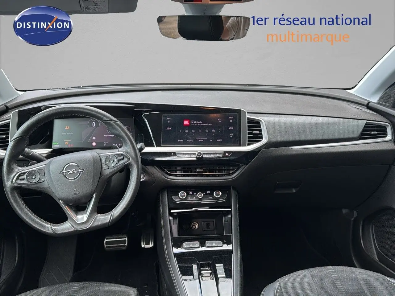 Vue intérieure frontale du tableau de bord noir de l'Opel Grandland 1.6 Turbo Hybrid 225ch avec écran tactile et volant multifonction.