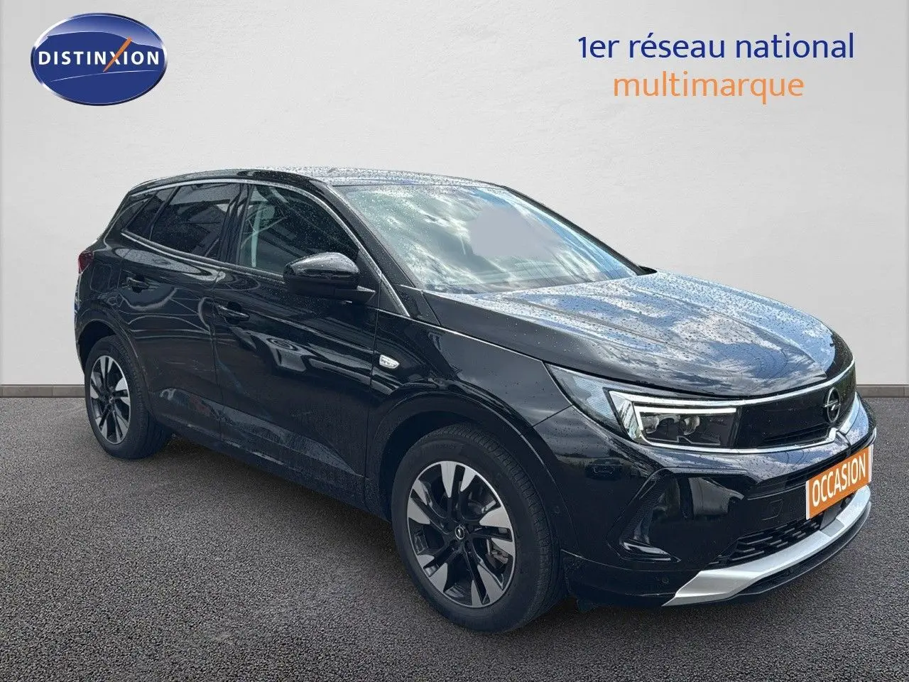 Opel Grandland noir en 3/4 avant droit, hybride rechargeable, jantes bi-ton et calandre chromée visible.