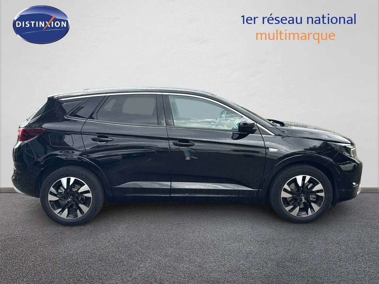 Profil droit d’un Opel Grandland 1.6 Turbo Hybrid 225ch GS noir brillant, avec jantes bi-ton et vitres teintées.