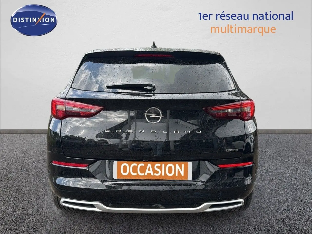 Vue arrière d'un Opel Grandland noir 2024 avec feux LED et logo distinctif sur un fond neutre.
