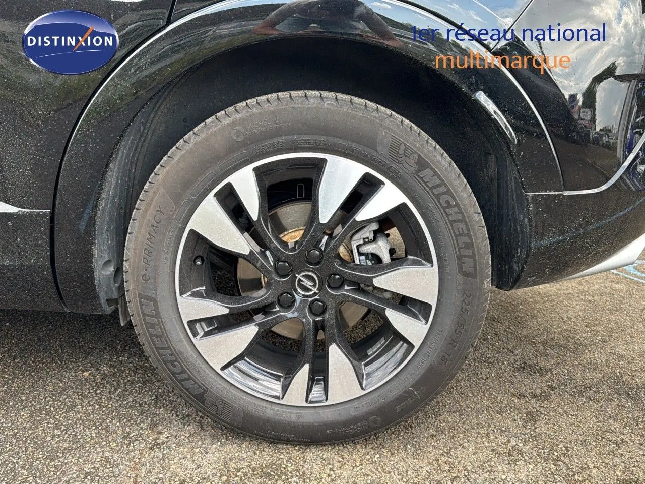 Gros plan sur la roue avant droite noire d’un Opel Grandland 2024 avec jante alliage bicolore et pneu Michelin.