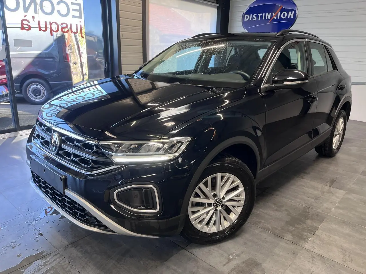 Volkswagen T-Roc Deep Black Pearlescent vue 3/4 avant droit en showroom avec jantes alliage et calandre chromée.