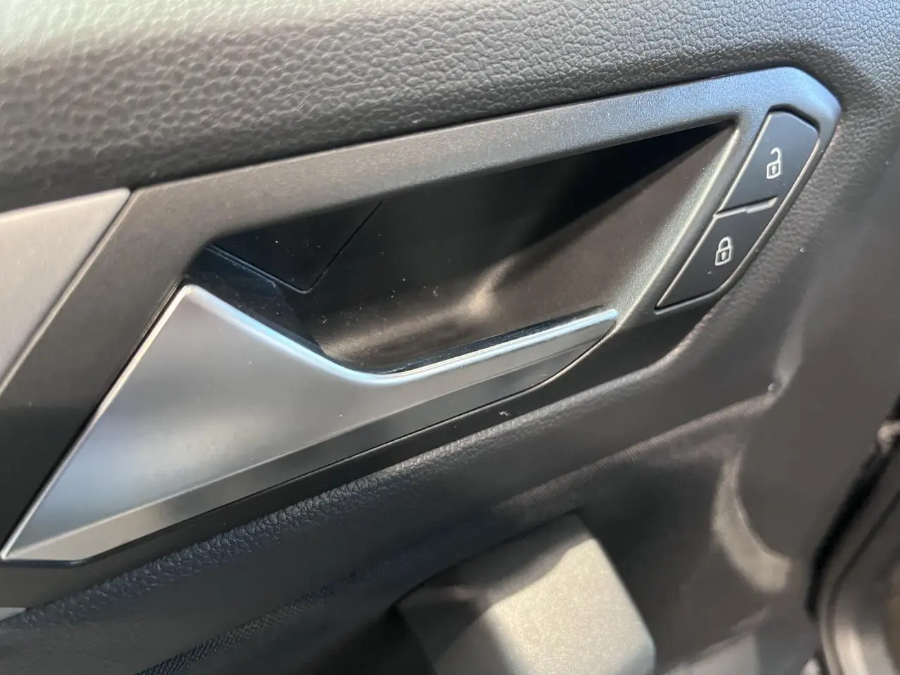 Poignée intérieure côté droit de porte Volkswagen T-Roc 2025 en noir avec boutons de verrouillage.