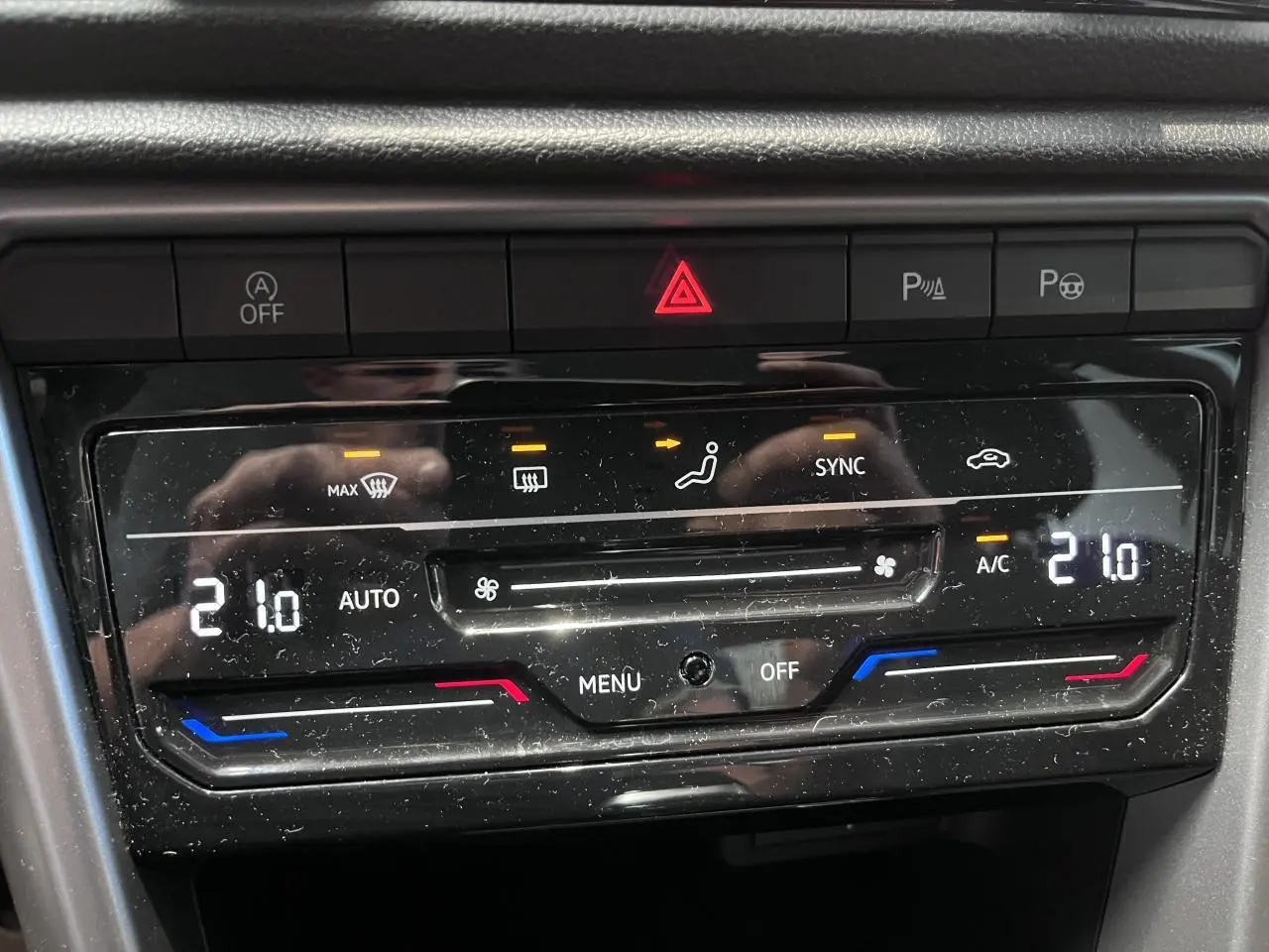 Gros plan sur la commande de climatisation automatique bi-zone du Volkswagen T-Roc Deep Black Pearlescent, affichant 21°C.