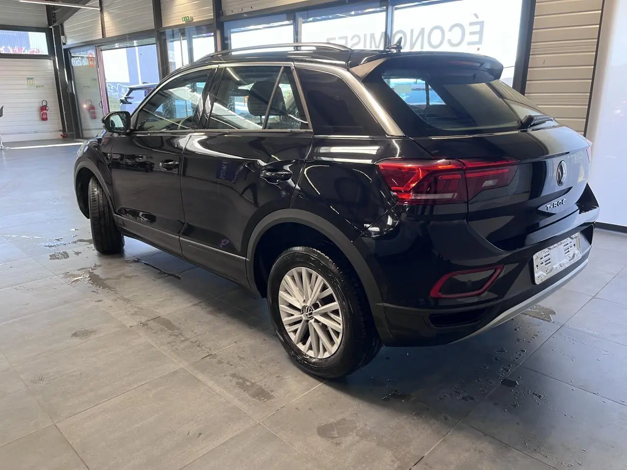 Volkswagen T-Roc Deep Black en 3/4 arrière droit, jantes alliage 16 pouces et feux arrière LED visibles.