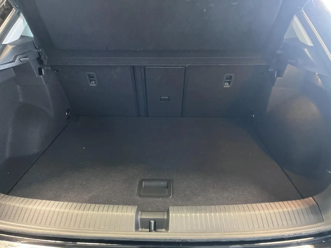 Coffre ouvert vu de face, intérieur spacieux et noir du Volkswagen T-Roc Deep Black Pearlescent 2025.