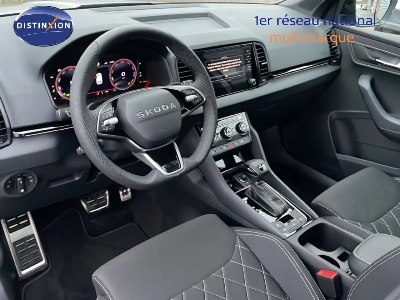 Vue intérieure côté conducteur du Skoda Karoq gris argent, avec volant multifonction et console centrale moderne.