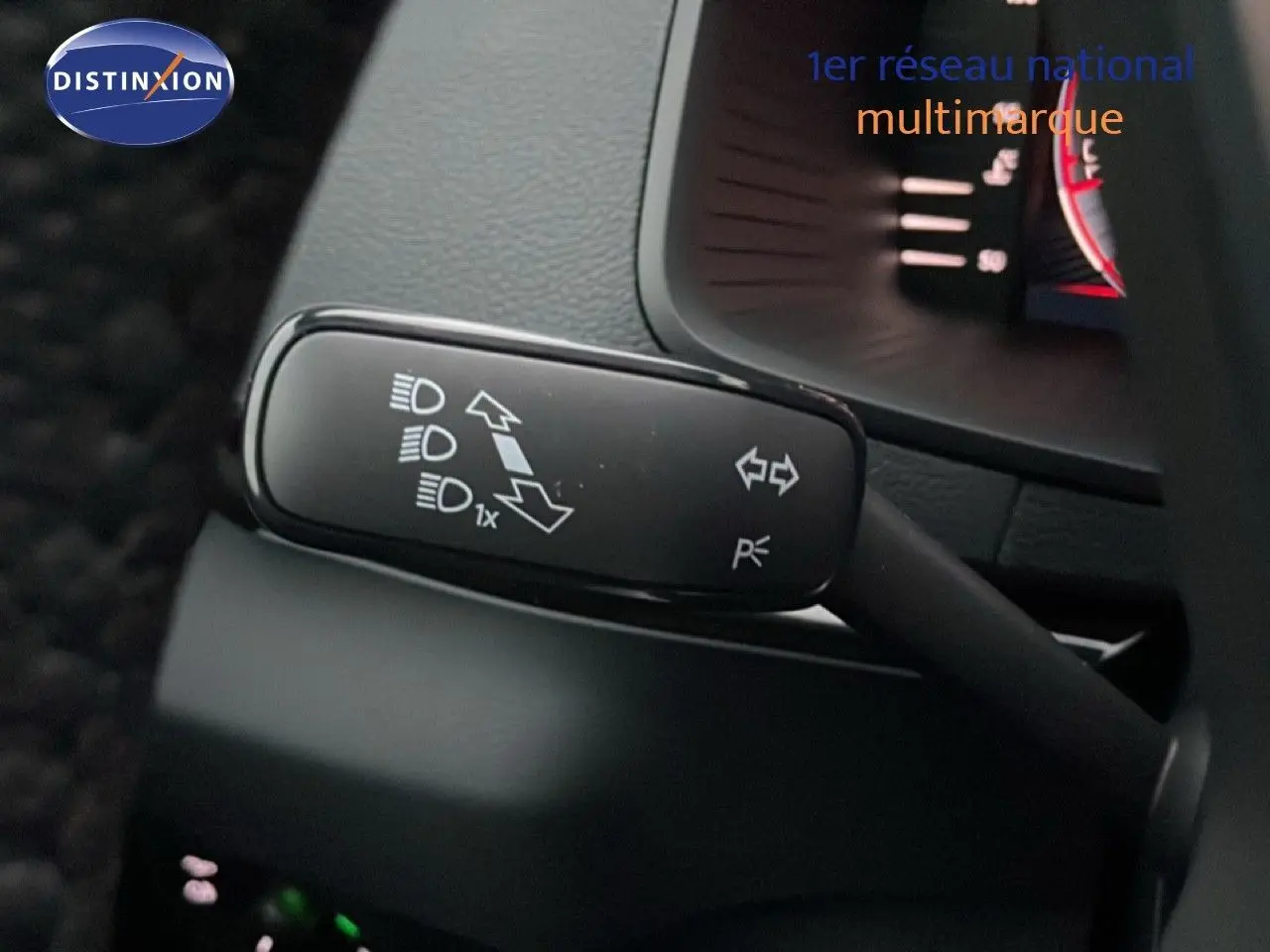 Gros plan sur la commande des clignotants et feux du Skoda Karoq gris argent 2025, intérieur noir visible.