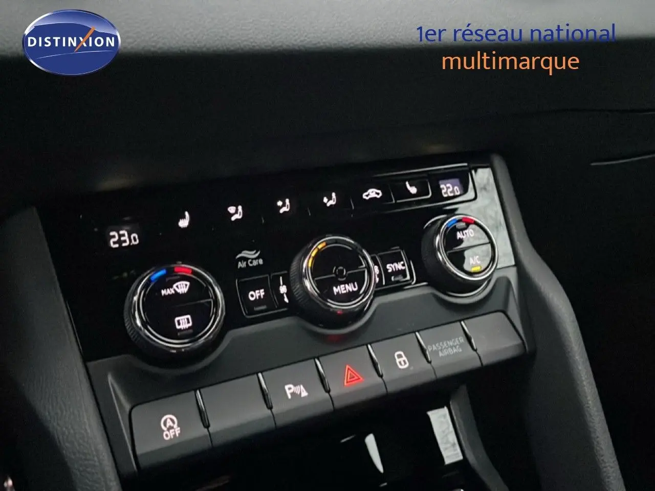 Vue rapprochée du tableau de bord du Skoda Karoq gris argent, mettant en valeur les commandes de climatisation et boutons de sécurité.