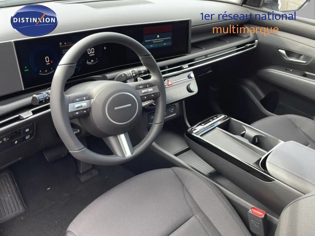 Vue intérieure côté conducteur du Hyundai Tucson 2026, tableau de bord moderne et sièges en tissu noir.