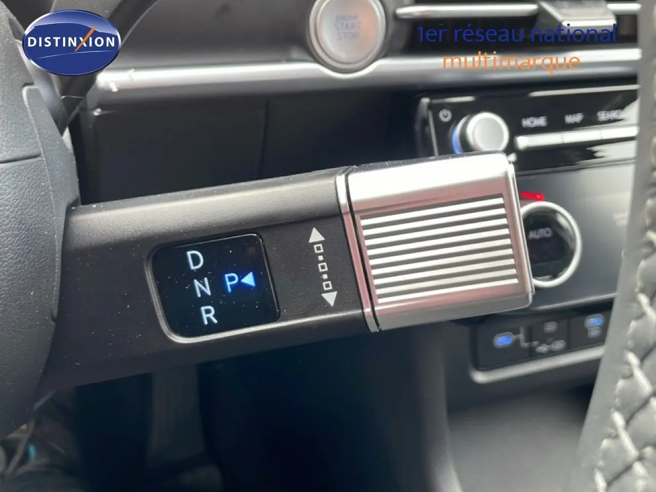 Gros plan sur la commande de boîte automatique du Hyundai Tucson blanc Atlas, avec affichage digital des modes D, N, R, P.