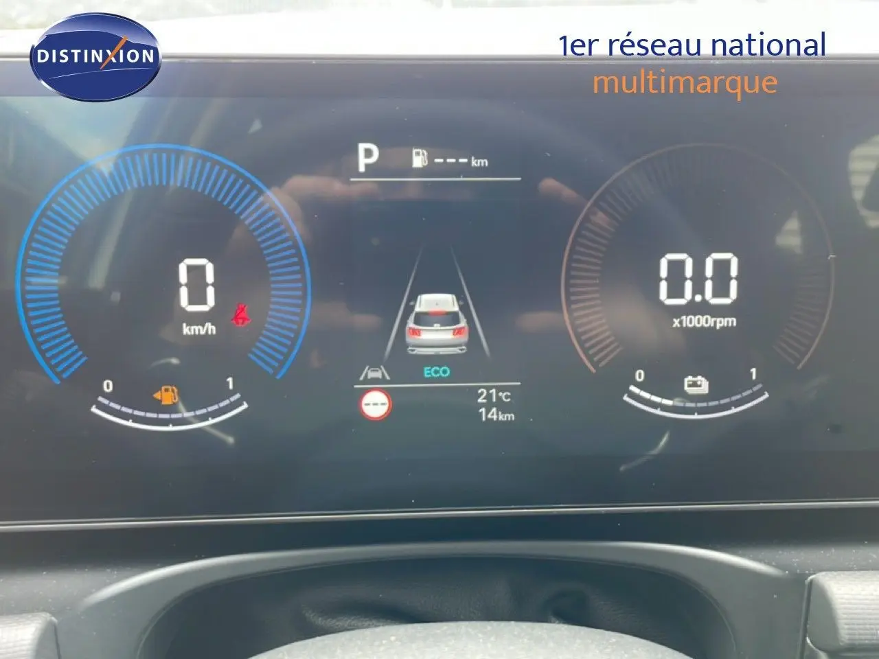 Tableau de bord numérique du Hyundai Tucson blanc, affichage de vitesse, régime moteur et indicateurs en vue frontale.