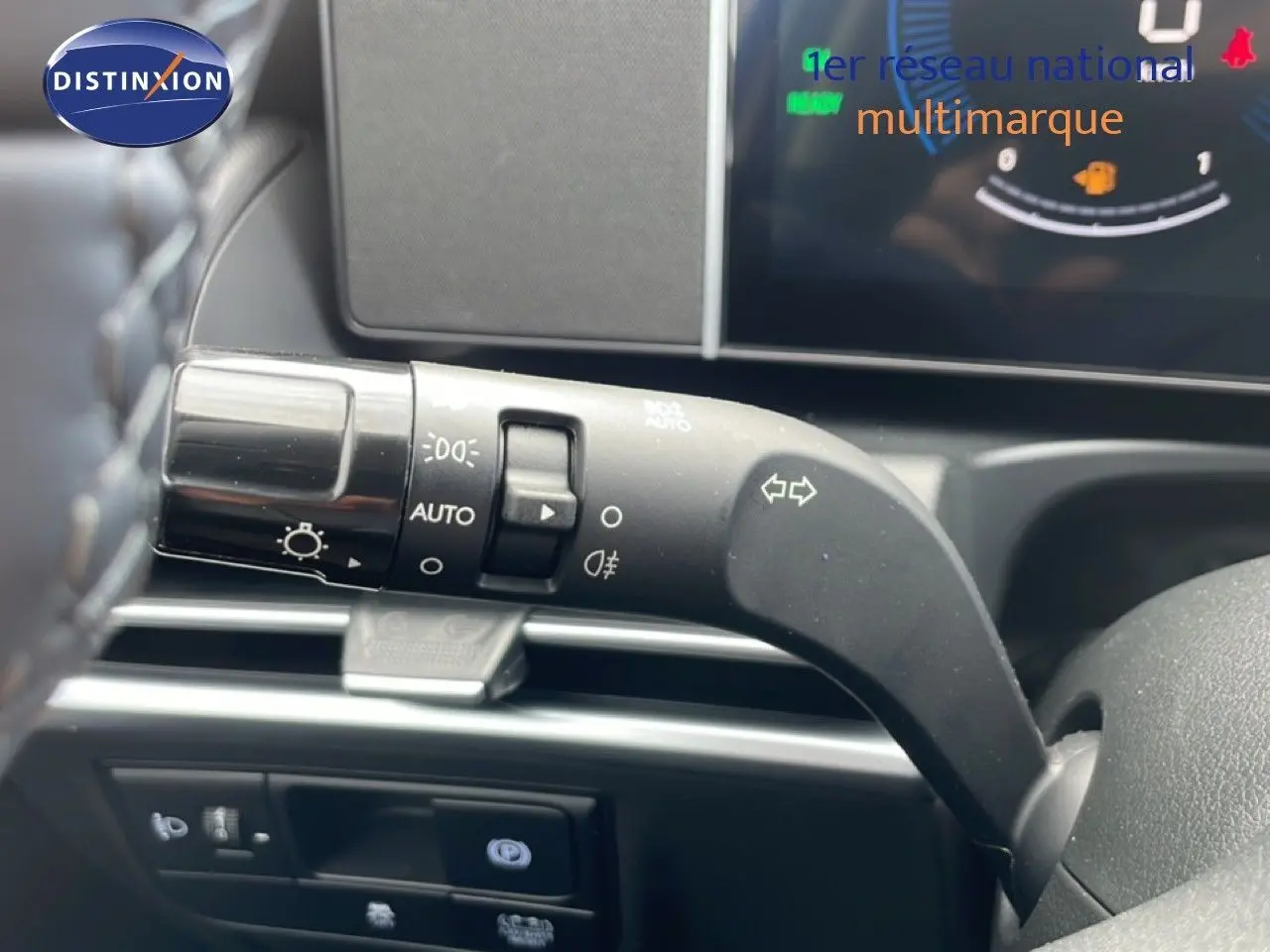 Gros plan sur la commande des feux et clignotants à gauche du volant dans l’habitacle du Hyundai Tucson blanc Atlas 2026.