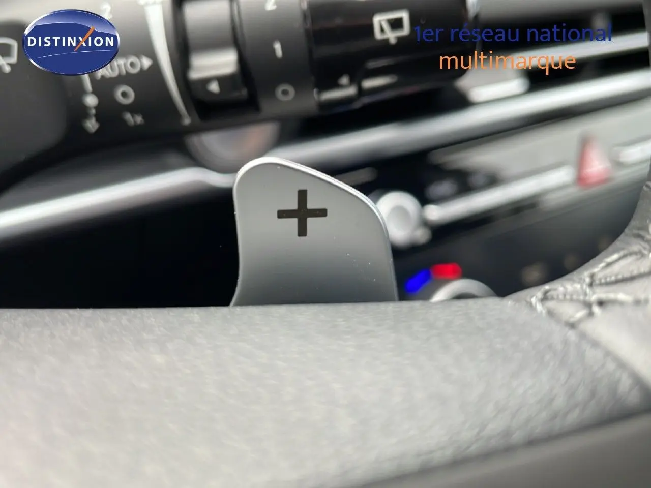 Gros plan sur la palette de changement de vitesse "+" côté droit du volant du Hyundai Tucson blanc Atlas 2026.
