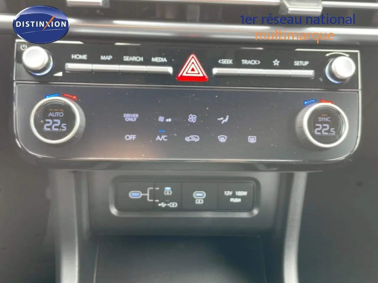 Vue rapprochée du tableau de bord du Hyundai Tucson 2026, montrant la climatisation digitale et les commandes multimédia.