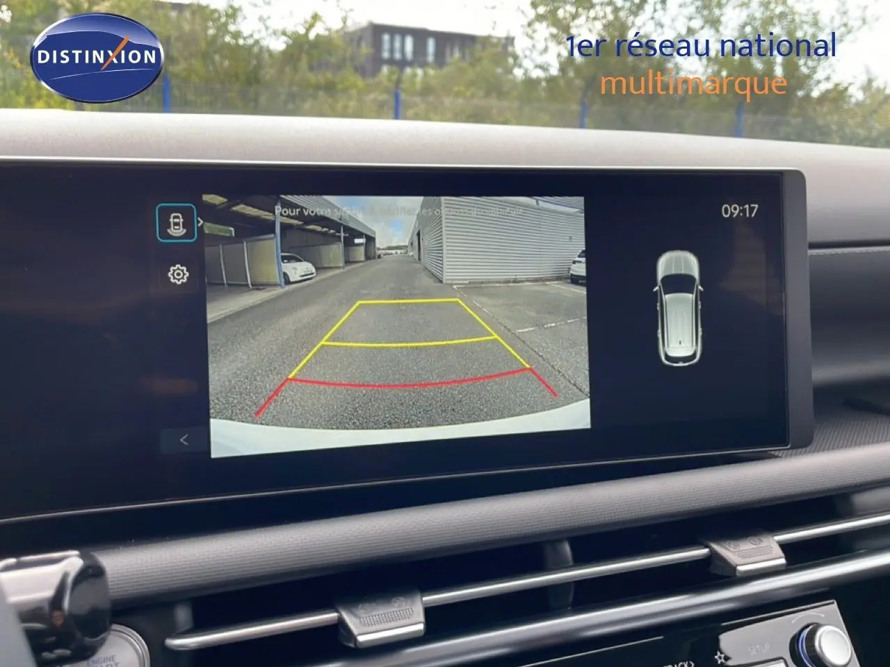 Vue de l'écran intérieur du Hyundai Tucson blanc Atlas 2026 montrant la caméra de recul avec lignes de guidage colorées.
