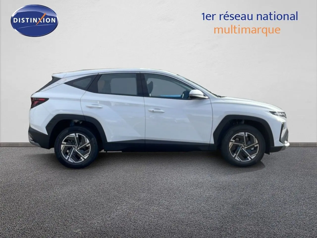 Profil droit d’un Hyundai Tucson blanc Atlas 2026 avec jantes bi-ton et lignes anguleuses marquées.