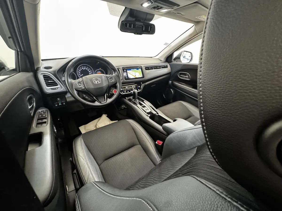 Intérieur noir du Honda HR-V 1.5 i-VTEC 130, vue avant côté conducteur avec tableau de bord et écran tactile.