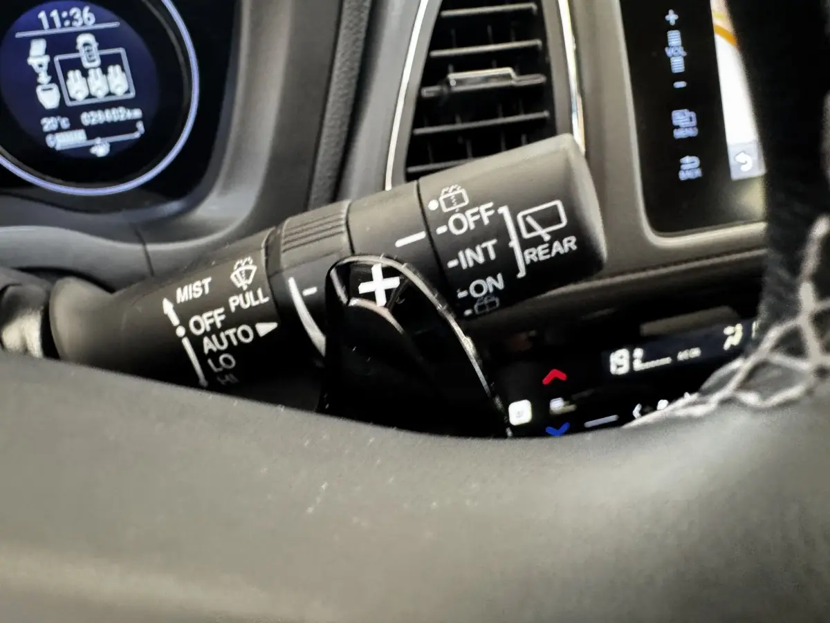 Gros plan sur la commande d'essuie-glace et palette de changement de vitesse dans le tableau de bord noir du Honda HR-V blanc 2019.
