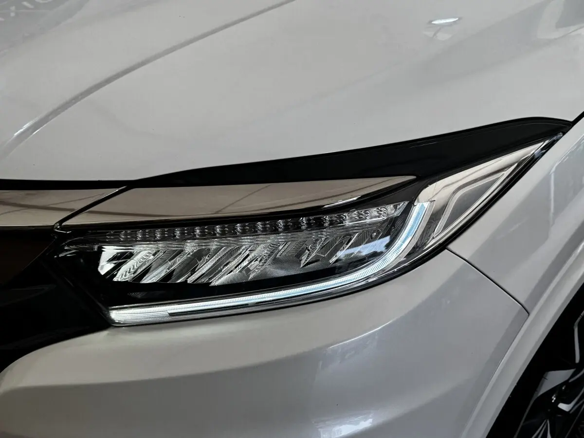 Gros plan sur le phare avant droit LED du Honda HR-V blanc 2019, soulignant son design moderne et précis.