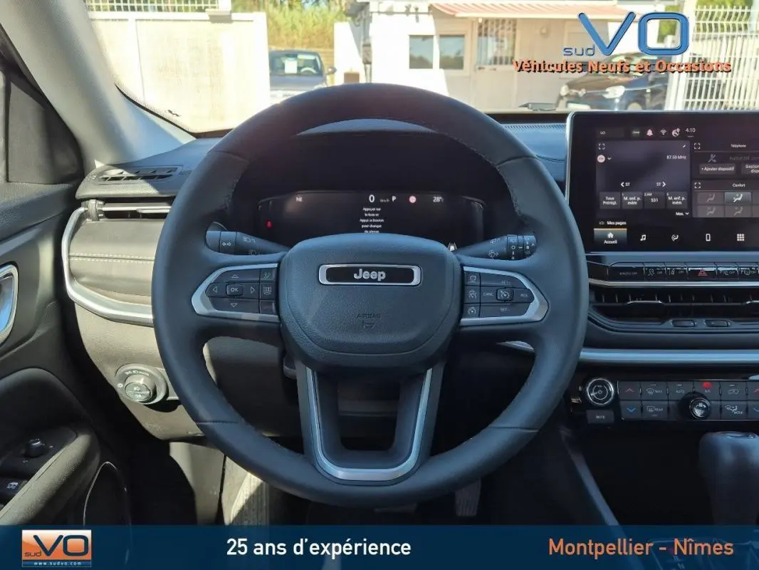 Vue frontale du volant Jeep Compass gris 2024 avec tableau de bord numérique et écran tactile central.