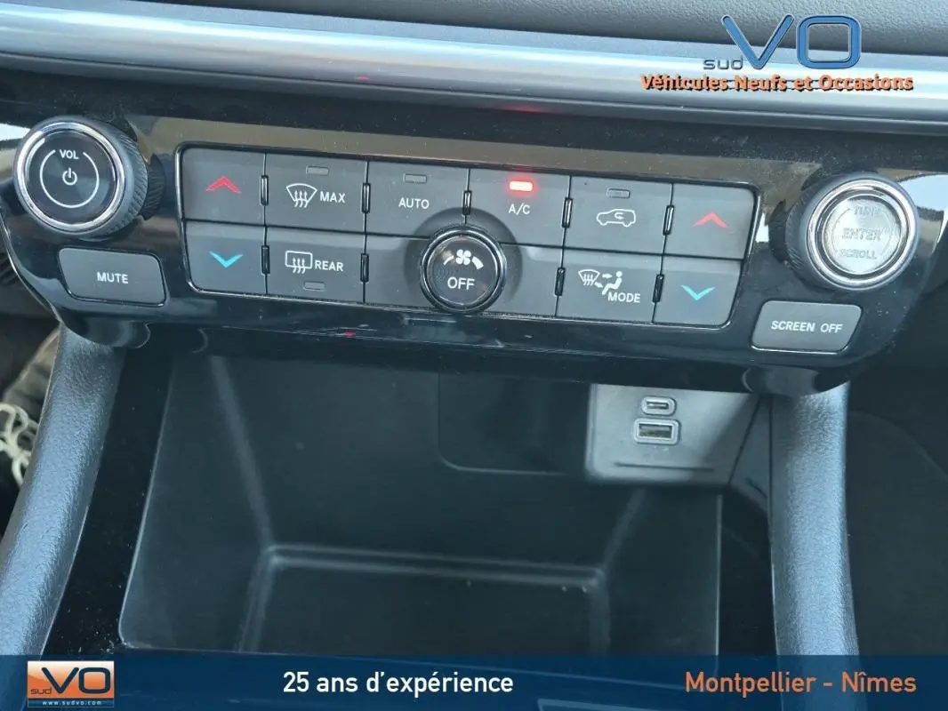 Vue rapprochée de la console centrale du Jeep Compass 2024, avec commandes climatisation et ports USB visibles.