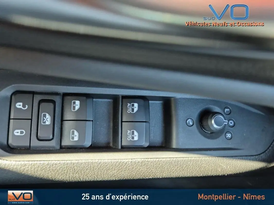 Commandes des vitres et rétroviseurs électriques sur la portière côté gauche d'un Jeep Compass gris 2024.