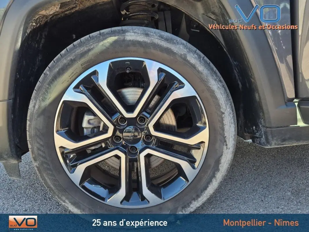 Gros plan sur la jante alliage 18 pouces noire et argent du côté avant droit du Jeep Compass gris 2024.