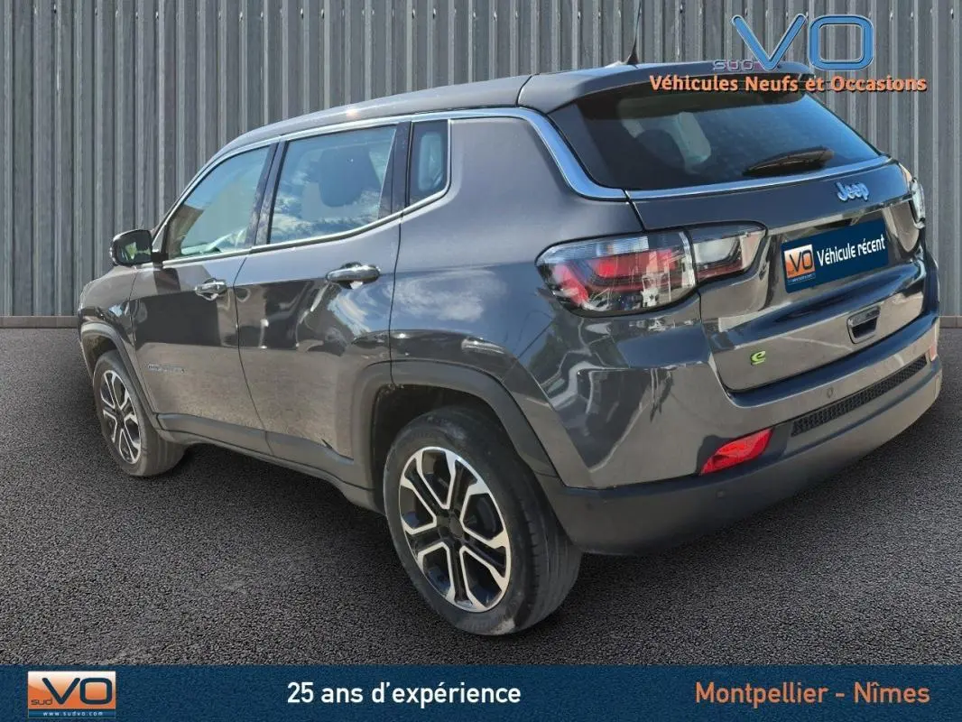 Jeep Compass gris en 3/4 arrière droit, jantes alliage 18 pouces et feux arrière LED visibles.