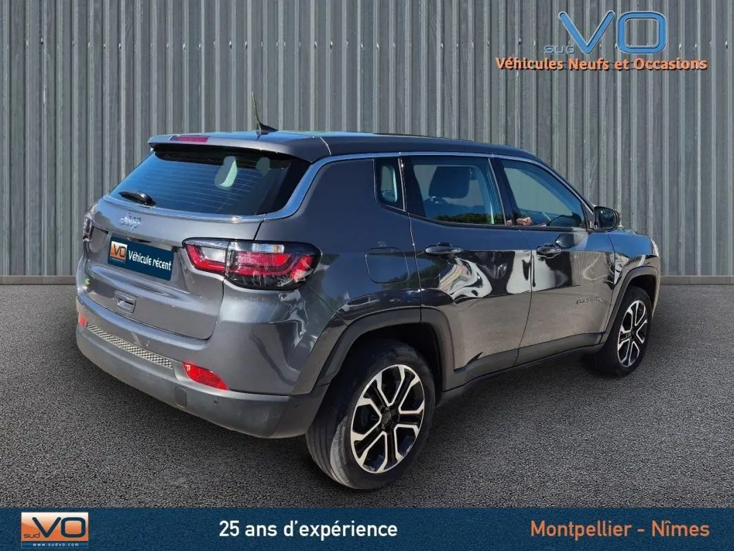 Jeep Compass gris 3/4 arrière droit, jantes alliage 18 pouces, SUV compact 2024 avec feux LED et toit noir.