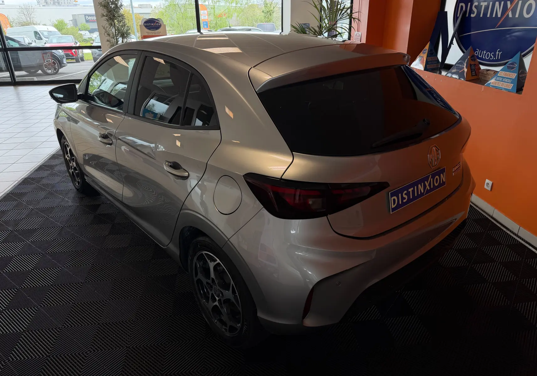 Vue 3/4 arrière gauche d'une MG3 cosmic silver 2025 en hybride, avec vitres arrière teintées et jantes alliage 16 pouces.