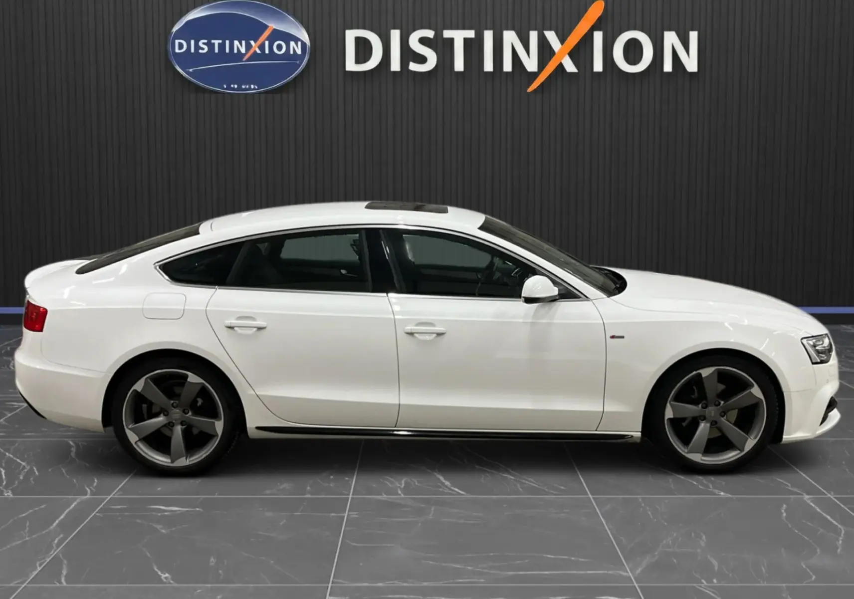 Profil droit d'une Audi A5 Sportback blanche de 2015 avec jantes bi-ton et toit ouvrant panoramique.