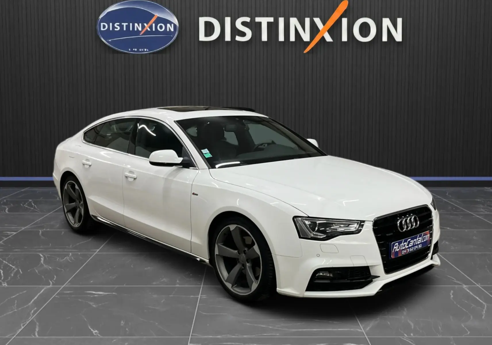 Audi A5 Sportback blanc vue 3/4 avant droit, avec jantes noires et toit ouvrant panoramique.